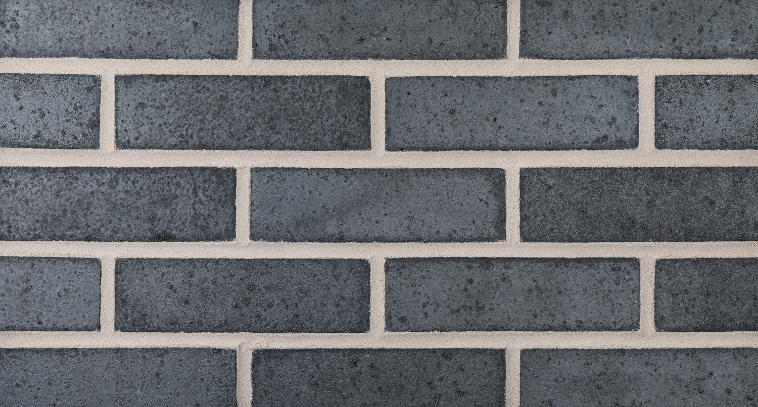 The Blue Smooth Ironspot brick is a dark blue-black through-body brick that make any modern design a standout project. Varying weather and lighting brings out the inherent luster and sheen in each individual brick.